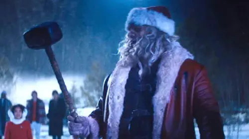 assets/david-harbour-as-santa-with-a-hammer-in-violent-night.jpeg