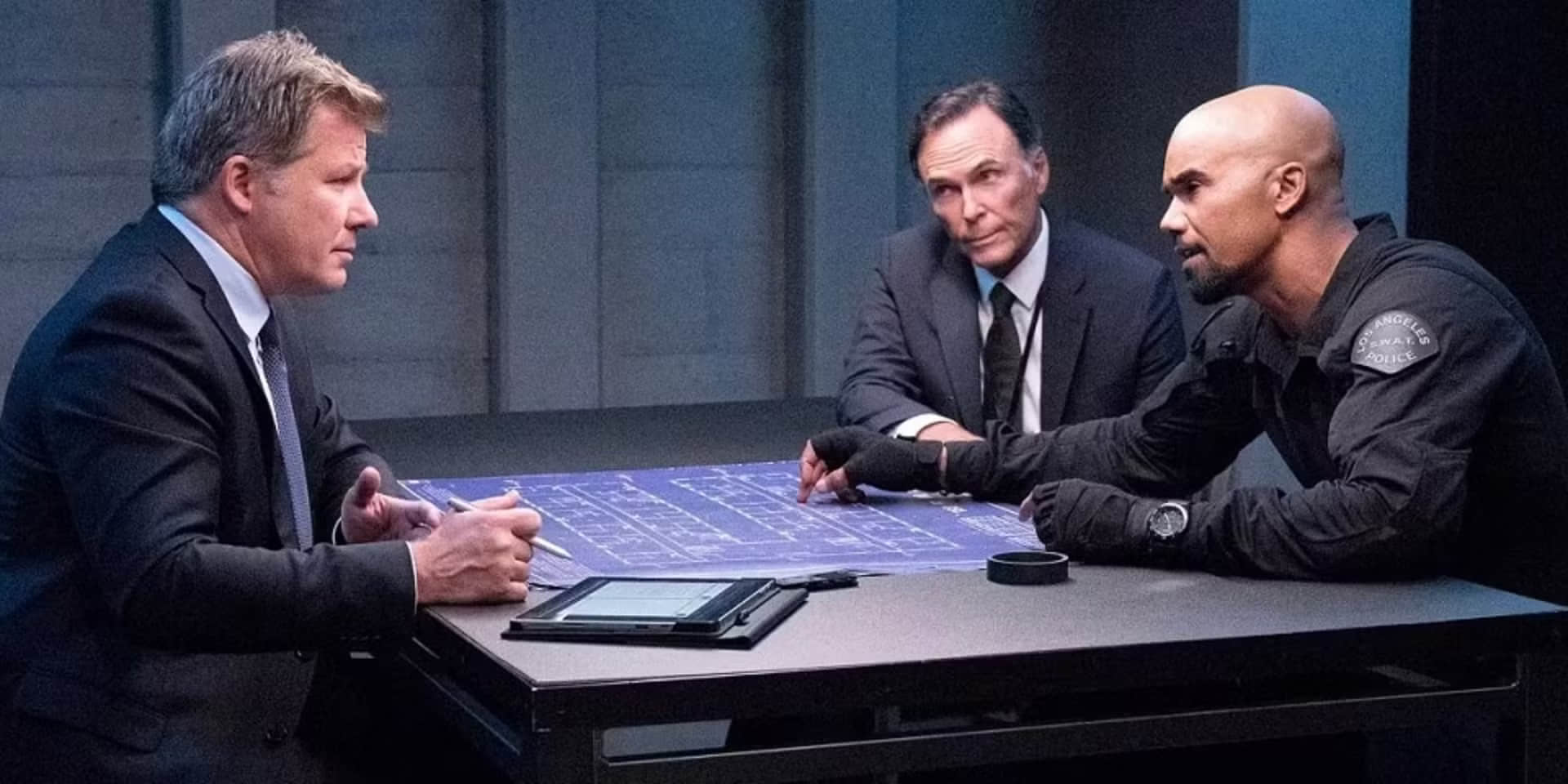 hondo-is-interrogated-with-a-set-of-blue-prints-on-the-table-in-front-of-him-in-the-swat-episode-day-of-dread