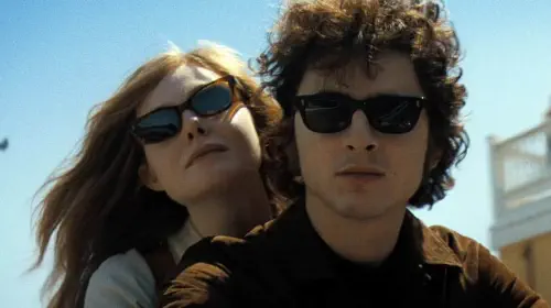 assets/timothee-chalamet-as-bob-dylan-and-elle-fanning-in-a-complete-unknown.jpeg