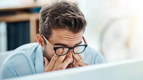 assets/Man-with-glasses-tiredly-rubbing-eyes-while-working-on-a-laptop-PC-1.jpeg