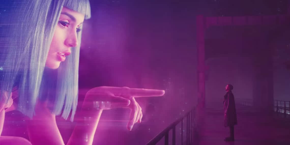 a-man-stands-on-a-bridge-where-a-hologram-tries-to-touch-him-in-blade-runner-2049