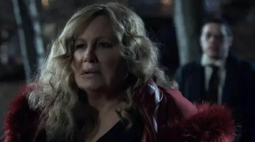 assets/jennifer-coolidge-in-a-red-fur-coat-in-the-woods-in-riff-raff-with-pete-davidson-behind-her.jpeg