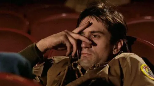 assets/robert-deniro-as-travis-bickle-with-fingers-over-his-eyes-in-a-scene-from-taxi-driver.jpeg