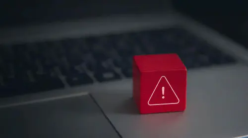 assets/Red-warning-cube-on-a-laptop-keyboard-in-darkened-room-1.jpeg