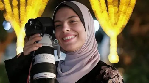assets/fatima-hassouna-holds-her-camera.jpeg