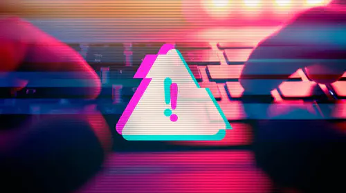 assets/Digital-warning-alert-while-man-types-on-a-keyboard-1.jpeg