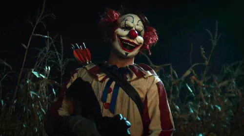 assets/a-clown-stands-in-front-of-a-cornfield-in-the-film-clown-in-a-cornfield.jpeg