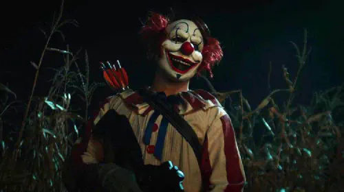 assets/a-clown-stands-in-front-of-a-cornfield-in-the-film-clown-in-a-cornfield.jpeg