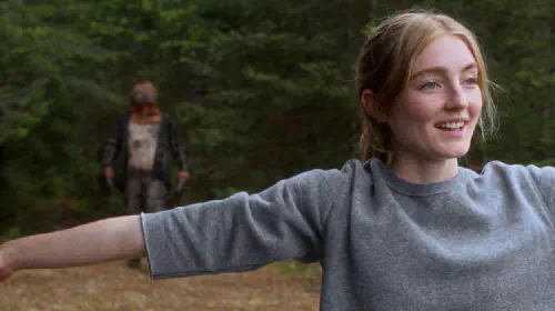 assets/a-girl-is-oblivious-to-the-figure-coming-behind-her-in-the-film-in-a-violent-nature.jpeg