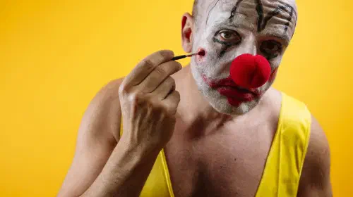 assets/sad-clown-putting-on-makeup-GettyImages-2187826511.jpeg