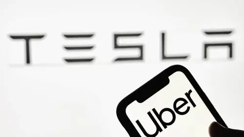assets/vecteezy_a-person-holds-smartphone-with-uber-trademark-with-tesla-logo_31173629-scaled.jpeg