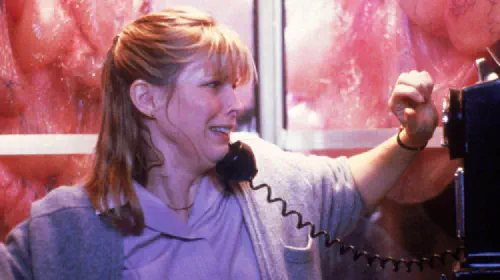 assets/a-woman-tries-to-use-a-phone-while-a-slime-surrounds-her-booth-in-the-blob.jpeg