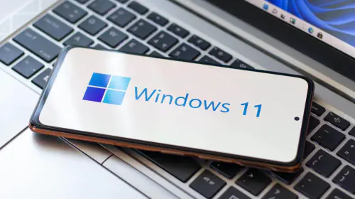 assets/Windows-11-logo-on-phone-sitting-on-laptop-keyboard-hero.jpeg