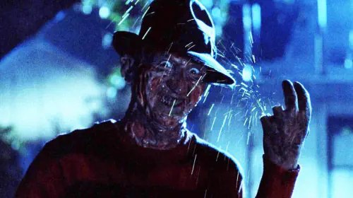 assets/robert-englund-smiling-while-he-chops-off-his-fingers-in-a-nightmare-on-elm-street.jpeg