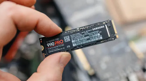 assets/Man-holding-Samsung-990-PRO-SSD-between-fingers-over-exposed-laptop-hero.jpeg