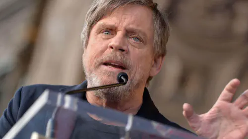 assets/mark-hamill-speaking-at-a-podium.jpeg