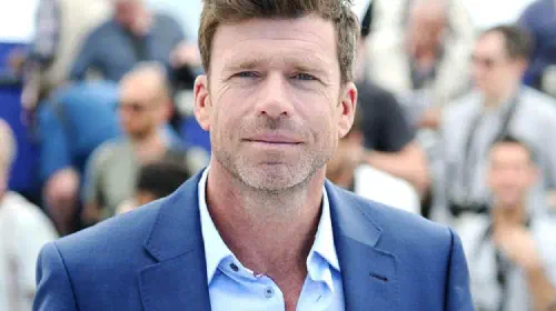 assets/taylor-sheridan-standing-in-front-of-a-crowd-at-cannes.jpeg