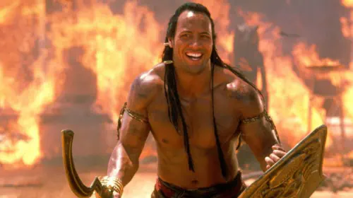 assets/shirtless-dwayne-johnson-as-mathayus-in-front-of-fire-in-the-scorpion-king.jpeg