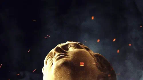 assets/a-statue-looking-upwards-as-ash-and-embers-fly-around-it-in-the-odyssey-poster.jpeg