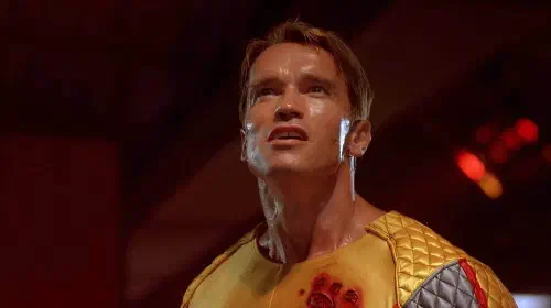 assets/arnold-schwarzenegger-with-blood-on-his-shirt-in-the-running-man.jpeg