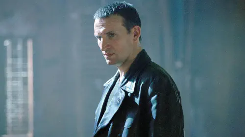 assets/christopher-eccleston-as-the-ninth-doctor-looking-serious-in-doctor-who.jpeg