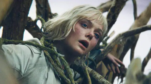 assets/elle-fanning-hangs-from-a-tree-in-predator-badlands.jpeg