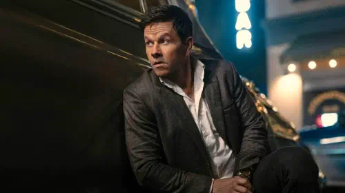assets/mark-wahlberg-in-play-dirty-leaning-against-a-car-in-a-suit.jpeg