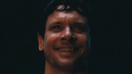 assets/jack-oconnell-smiling-with-glowing-red-eyes-in-sinners.jpeg