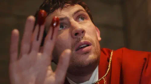 assets/josh-o-connor-holding-up-bloody-fingers-in-wake-up-dead-man.jpeg