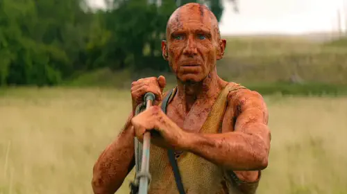 assets/ralph-fiennes-as-kelson-looking-uncertain-while-holding-his-blow-gun-in-28-years-later-the-bone-temple.jpeg