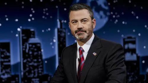 assets/jimmy-kimmel-sitting-at-his-desk-with-a-serious-look-on-his-face.jpeg