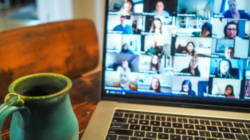 assets/Zoom-video-conference-call-on-MacBook-laptop-screen-with-mug-beside.jpeg