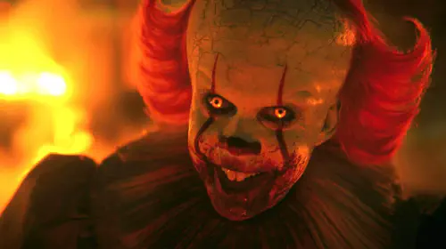 assets/bill-skarsga-rd-s-pennywise-smiling-with-his-eyes-glowing-in-it-welcome-to-derry-episode-7.jpeg