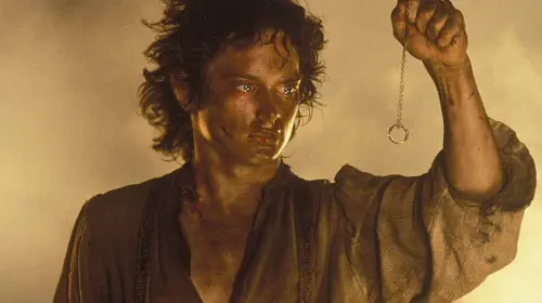 assets/a-dirty-and-exhausted-frodo-holding-the-one-ring-on-a-chain-in-front-of-him-in-the-lord-of-the-rings-the-return-of-the-king.jpeg