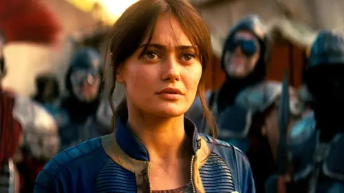 assets/ella-purnell-s-lucy-standing-among-a-group-of-caesar-s-legion-soldiers-in-fallout-season-2.jpeg