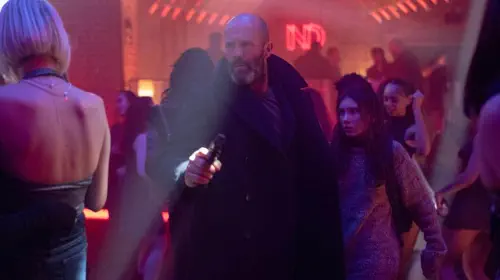 assets/jason-statham-walks-through-a-crowd-with-a-little-girl-in-shelter.jpeg