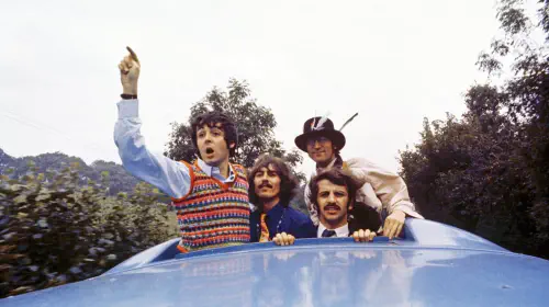 assets/the-beatles-standing-up-in-a-car.jpeg