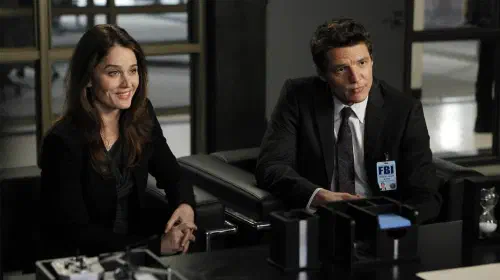 assets/pedro-pascal-and-robin-tunney-smiling-together-and-sitting-in-an-episode-of-the-mentalist.jpeg