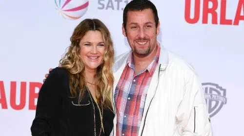assets/drew-barrymore-and-adam-sandler-smiling-arm-in-arm-on-a-red-carpet.jpeg