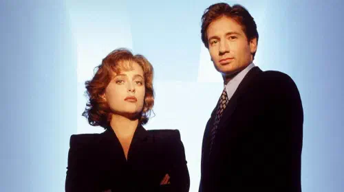 assets/gillian-anderson-and-david-duchovny-standing-together-in-a-promo-photo-for-the-early-seasons-of-the-x-files.jpeg