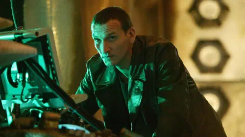 assets/christopher-eccleston-as-the-ninth-doctor-leaning-over-a-computer-in-doctor-who-season-1.jpeg