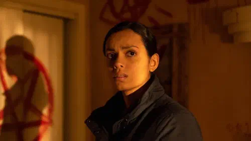 assets/georgina-campbell-as-jane-archer-looking-around-a-room-with-demonic-symbols-in-psycho-killer.jpeg