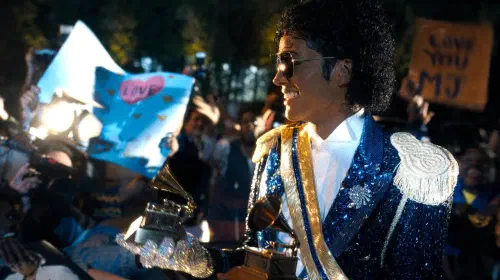 assets/jaafar-jackson-s-michael-jackson-holding-a-grammy-and-smiling-while-looking-out-at-a-crowd-in-michael.jpeg