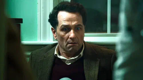 assets/matthew-rhys-tom-looking-shocked-while-leaning-against-a-wall-in-widow-s-bay.jpeg