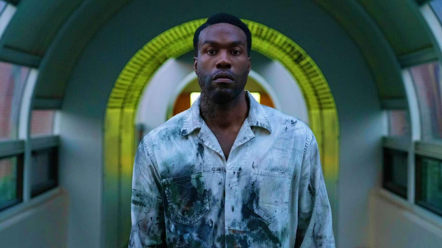 yahya-abdul-mateen-ii-as-anthony-looking-intense-underneath-a-yellow-arch-in-candyman-2021.jpeg