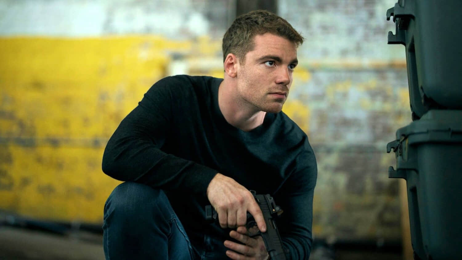 gabriel-basso-as-peter-hiding-behind-boxes-in-the-night-agent-season-3.jpeg
