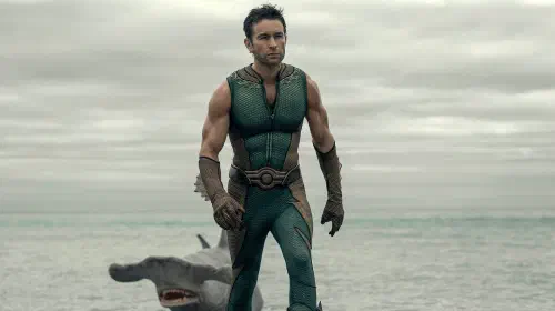 assets/chace-crawford-as-the-deep-walking-from-the-ocean-with-a-hammerhead-shark-behind-him-in-the-boys-season-5.jpeg
