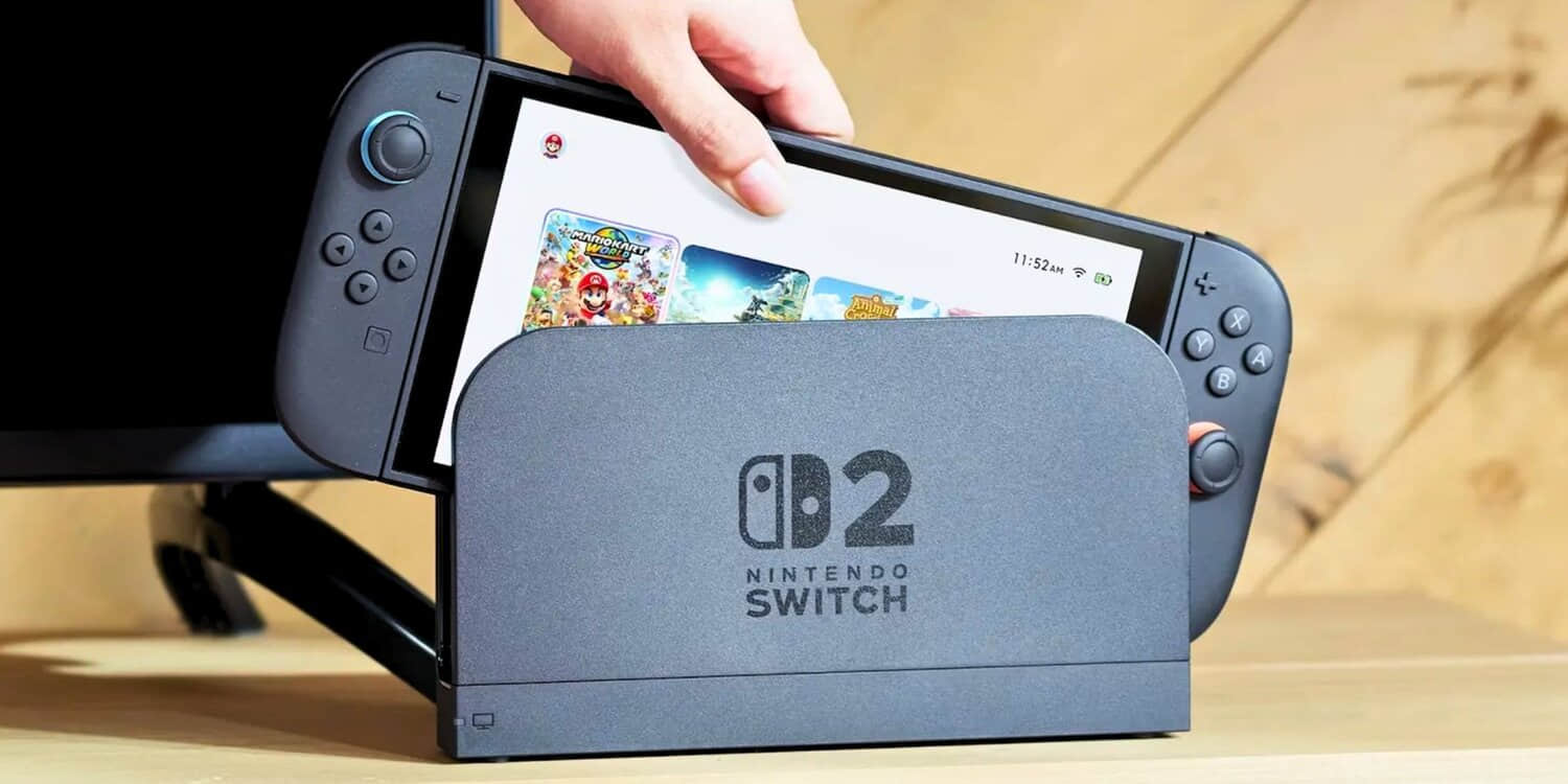 nintendo-switch-2-being-loaded-into-a-dock-with-the-home-screen-visible-as-it-s-being-placed-inside-the-dock-by-a-person-s-hand.jpeg