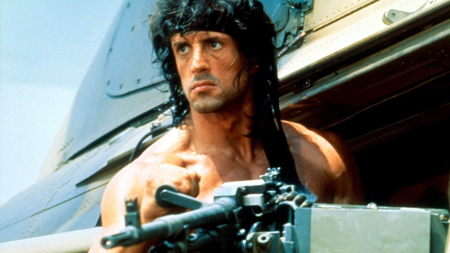 sylvester-stallone-as-john-rambo-leaning-out-of-a-helicopter-with-a-gun-in-rambo-iii.jpeg
