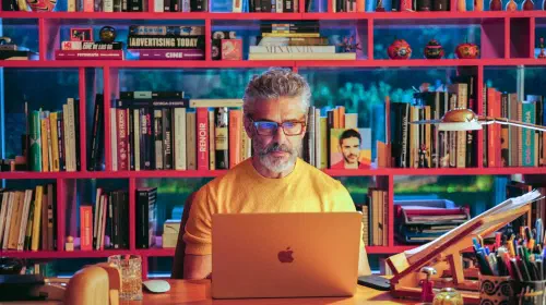 assets/ra-l-at-his-computer-in-front-of-a-bookshelf-in-bitter-christmas.jpeg